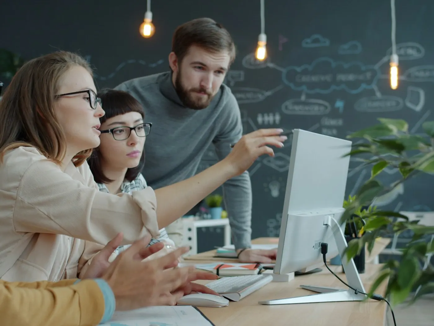 Un equipo trabajando junto frente a una computadora